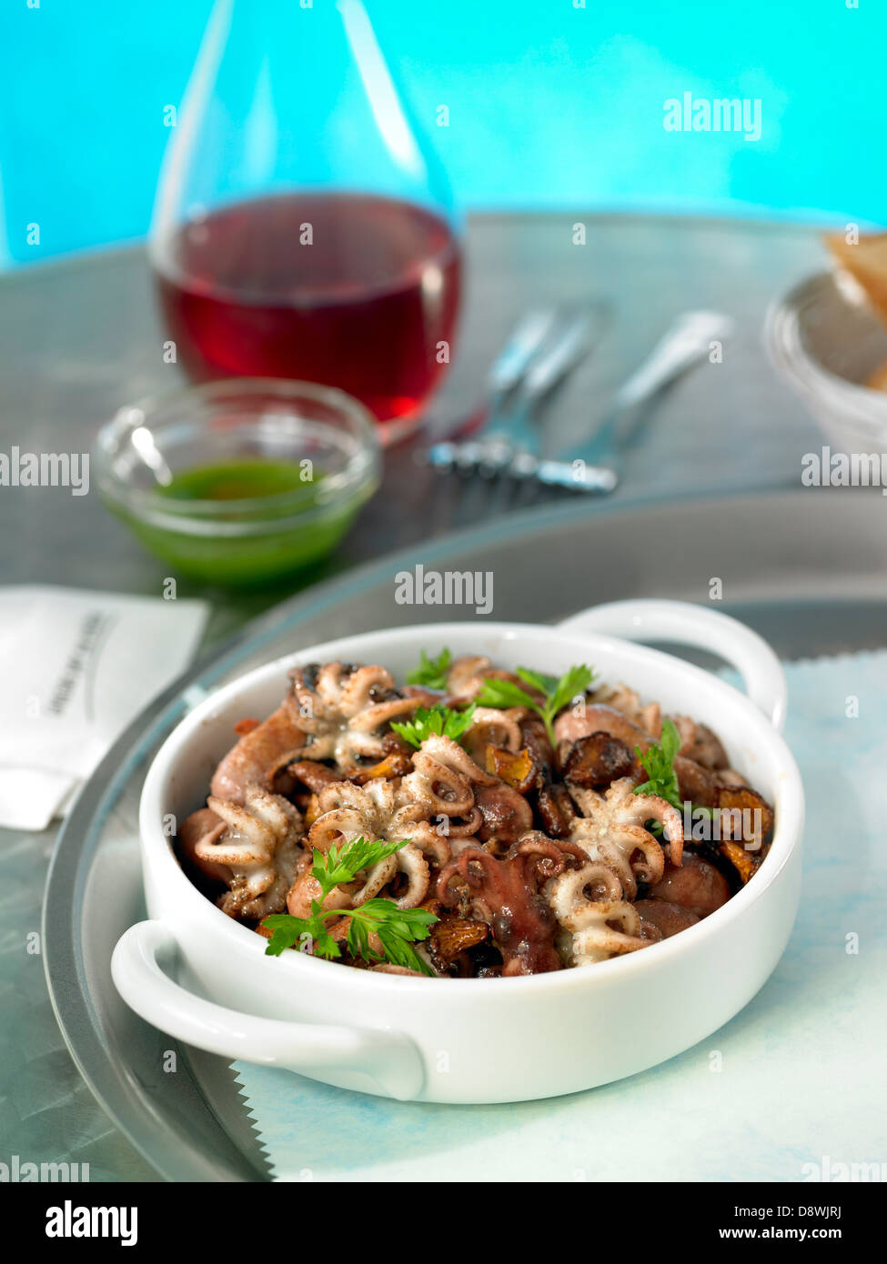 Sauteed small octopus with mushrooms and sausage Stock Photo