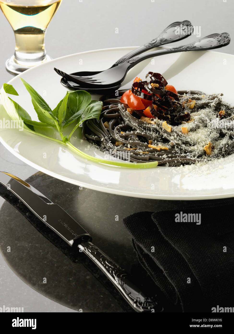 Squid ink spaghetti with purple peppers Stock Photo