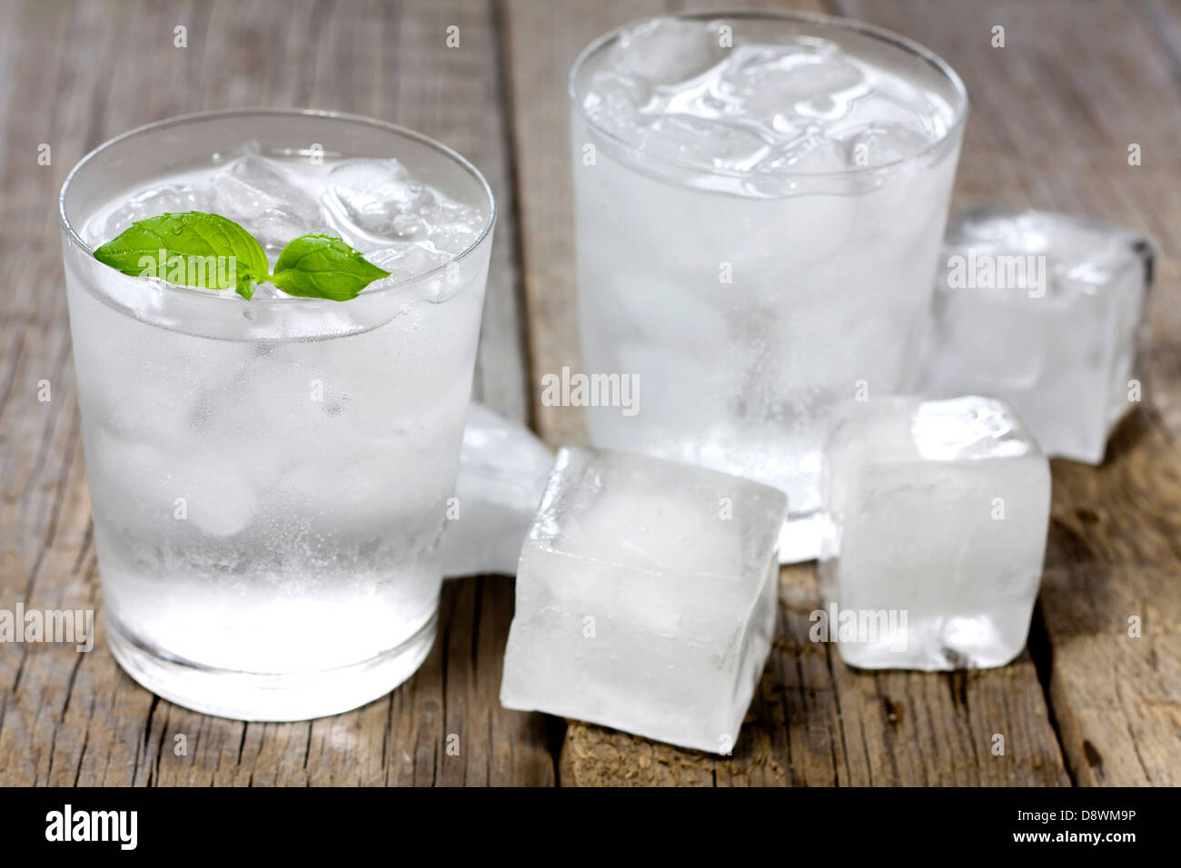 Glass of water with ice cubes on vintage wooden boards Stock Photo