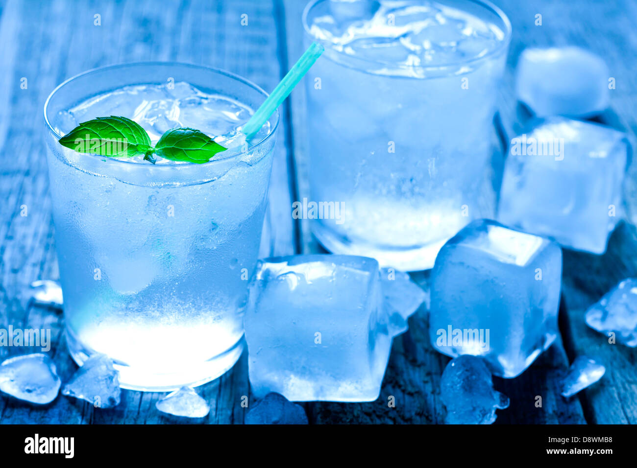 Glass of water with ice cubes on vintage wooden boards Stock Photo