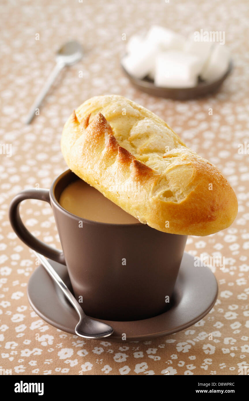 Cup of milk coffee and a milkbread sugar bun Stock Photo