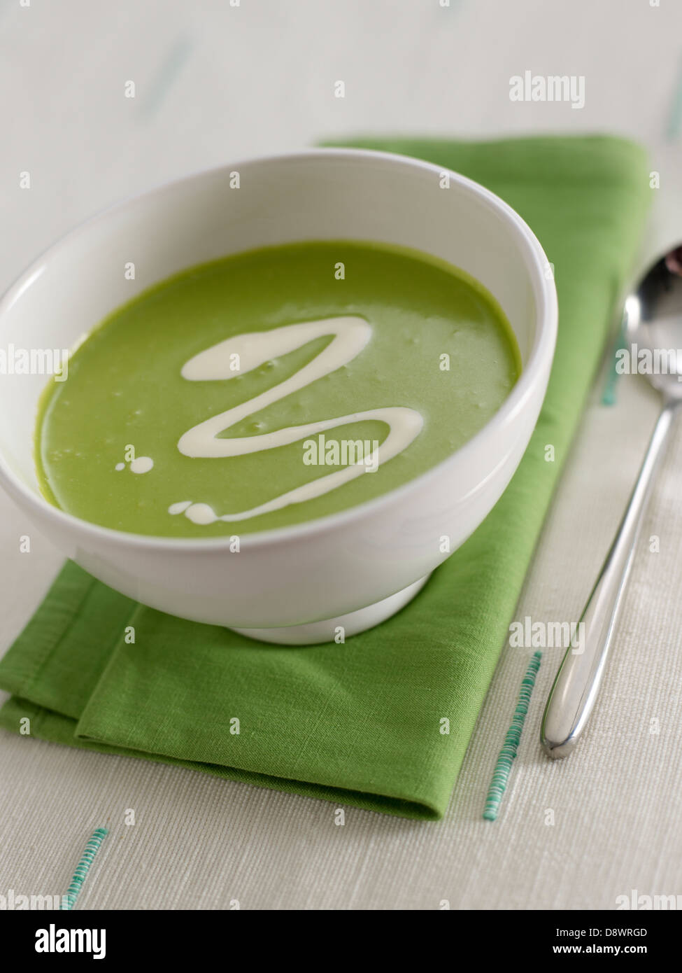 green soup white zigzag table tablecloth napkin spoon Stock Photo