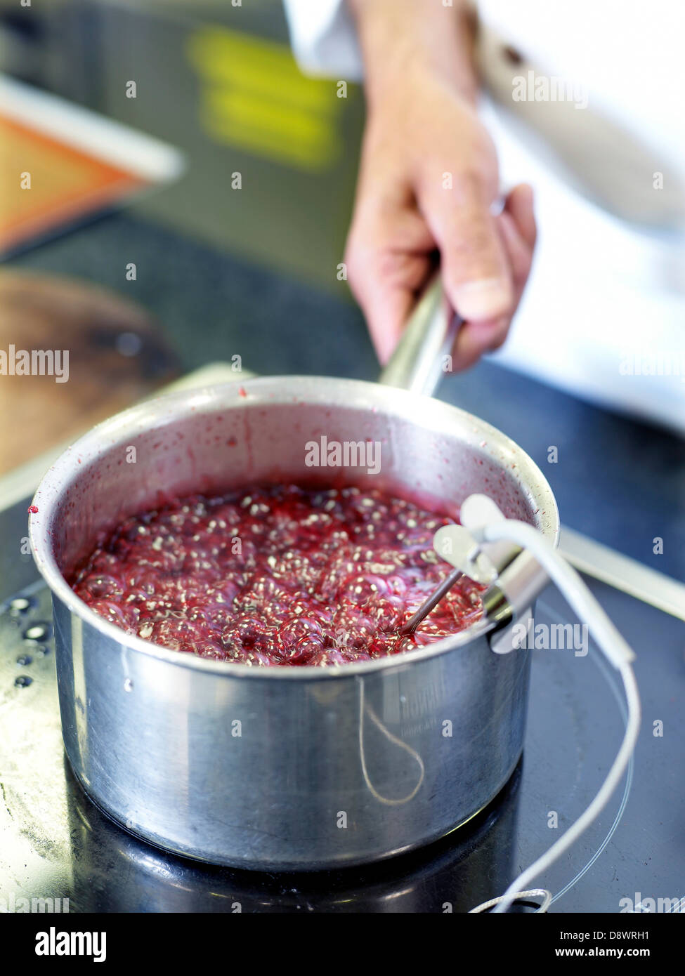 Taking the temperature of jam cooking in a saucepan Stock Photo Alamy