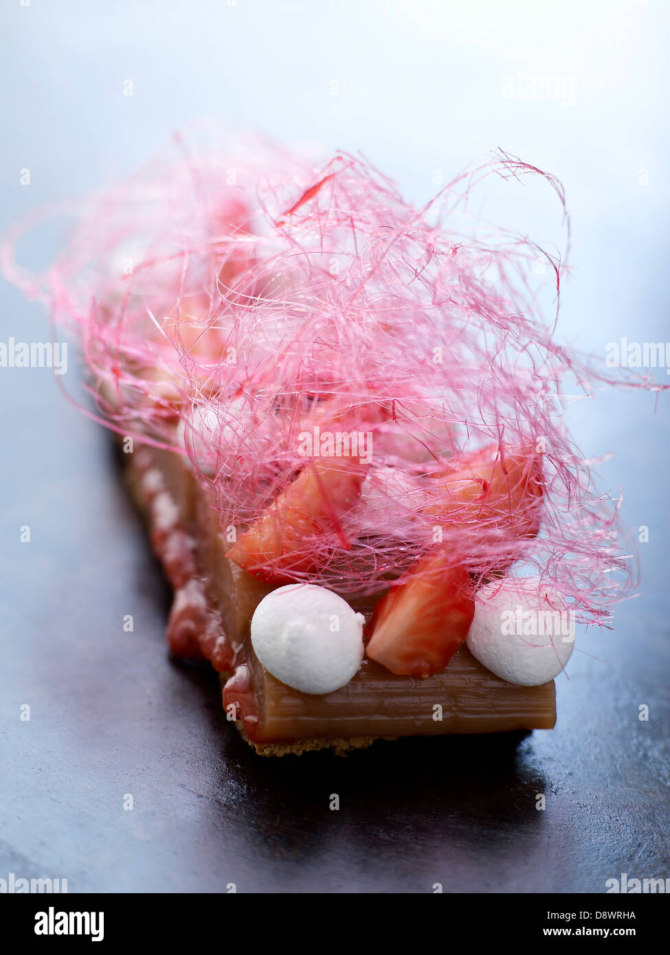 Shortbread biscuit with stewed rhubarb,strawberries,meringues and cotton candy Stock Photo