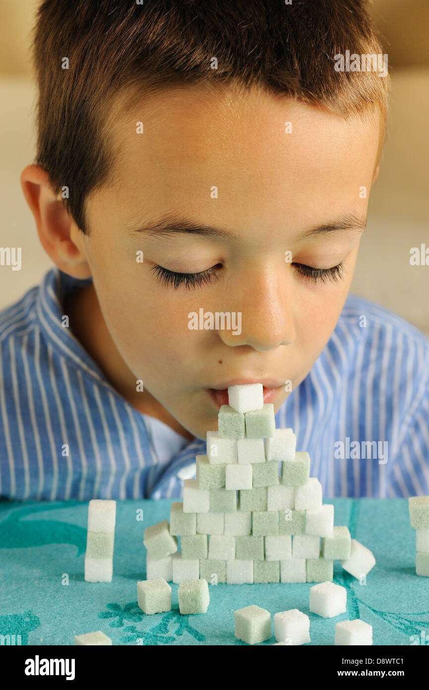 Young boy playing with colored sugar lumps Stock Photo