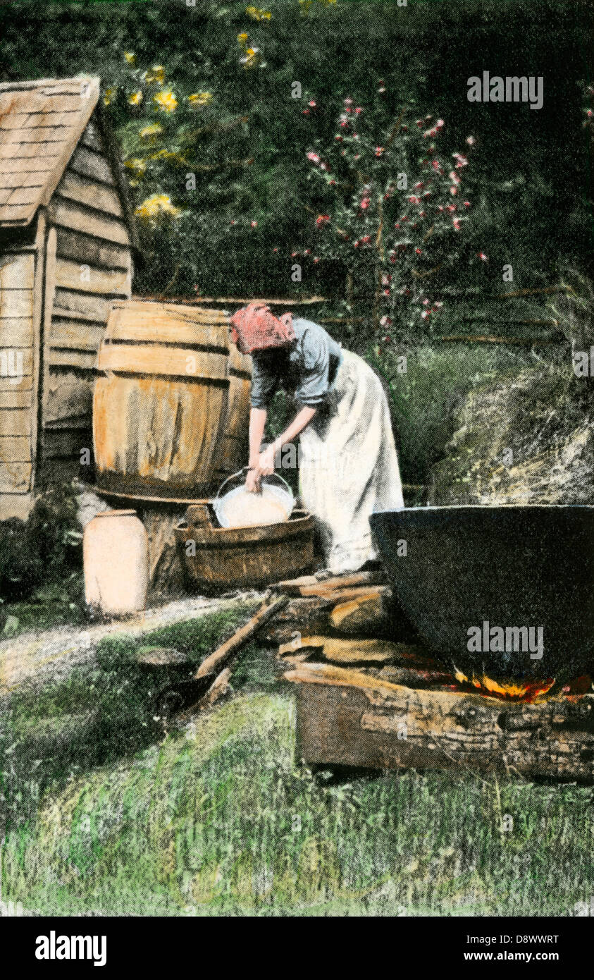 Woman making soft soap by hand with an outdoor kettle to render lard