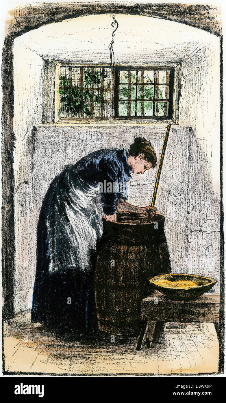 Woman bending over a churn to gather butter. Hand-colored woodcut Stock Photo