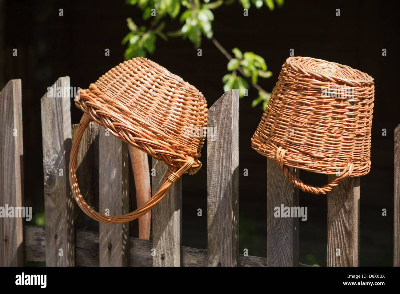 Two wicker baskets hanging on the wooden fence Stock Photo Alamy