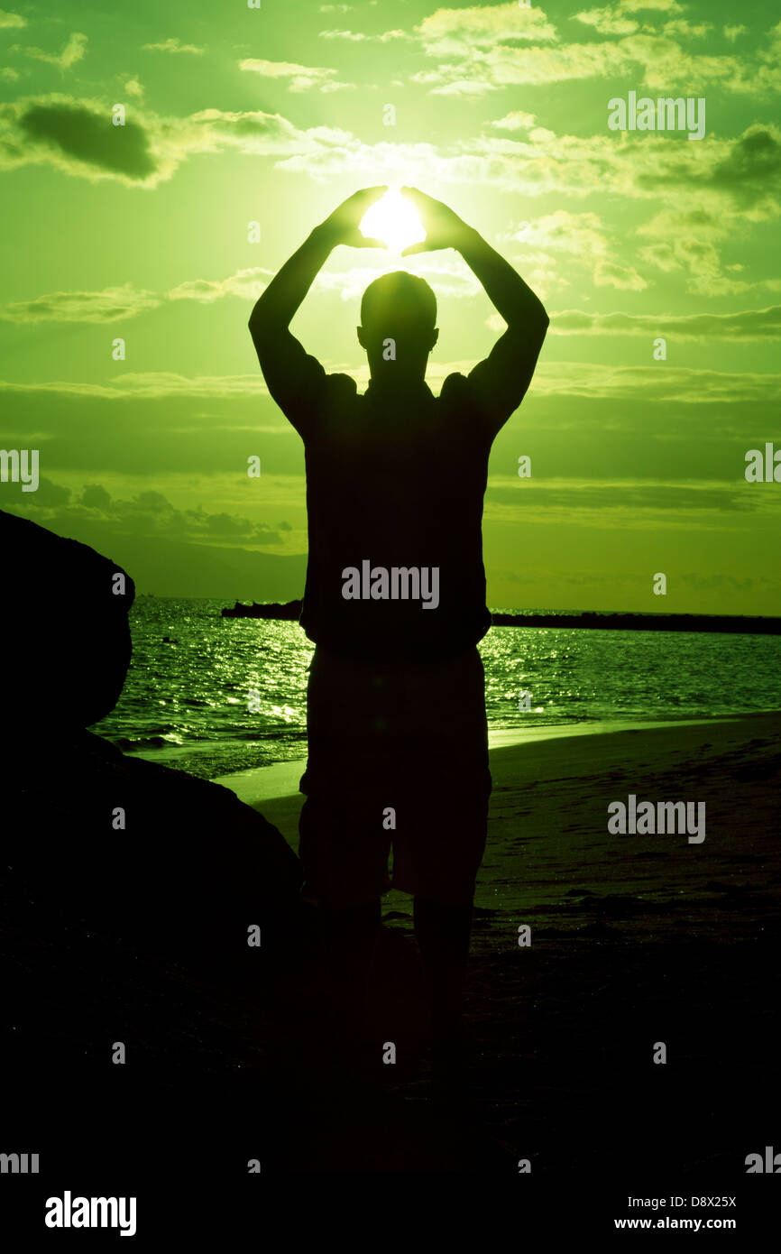 Silhouette of male holding the sun Stock Photo
