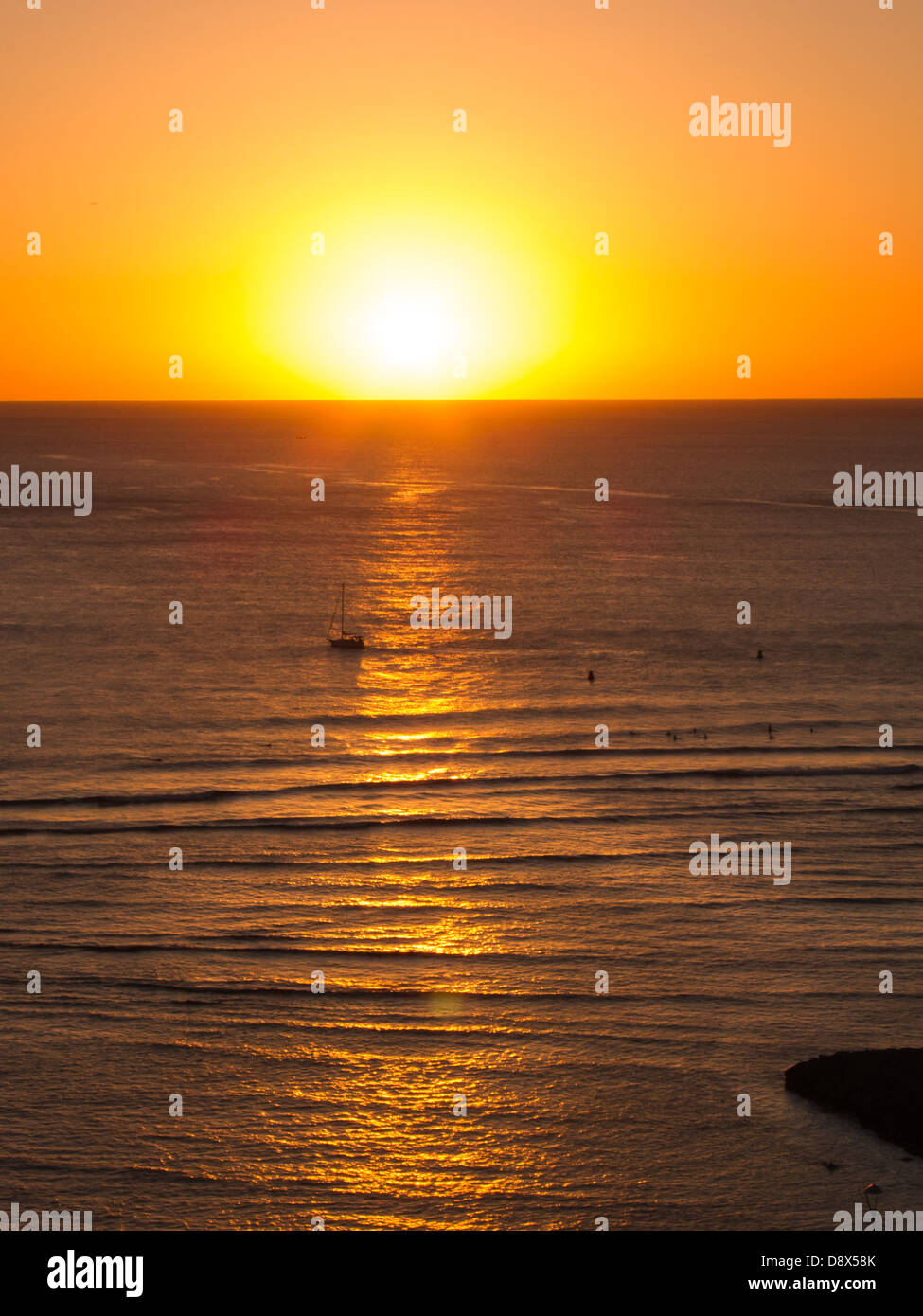 Sunset off of Waikiki with golden highlights reflected in the water Stock Photo