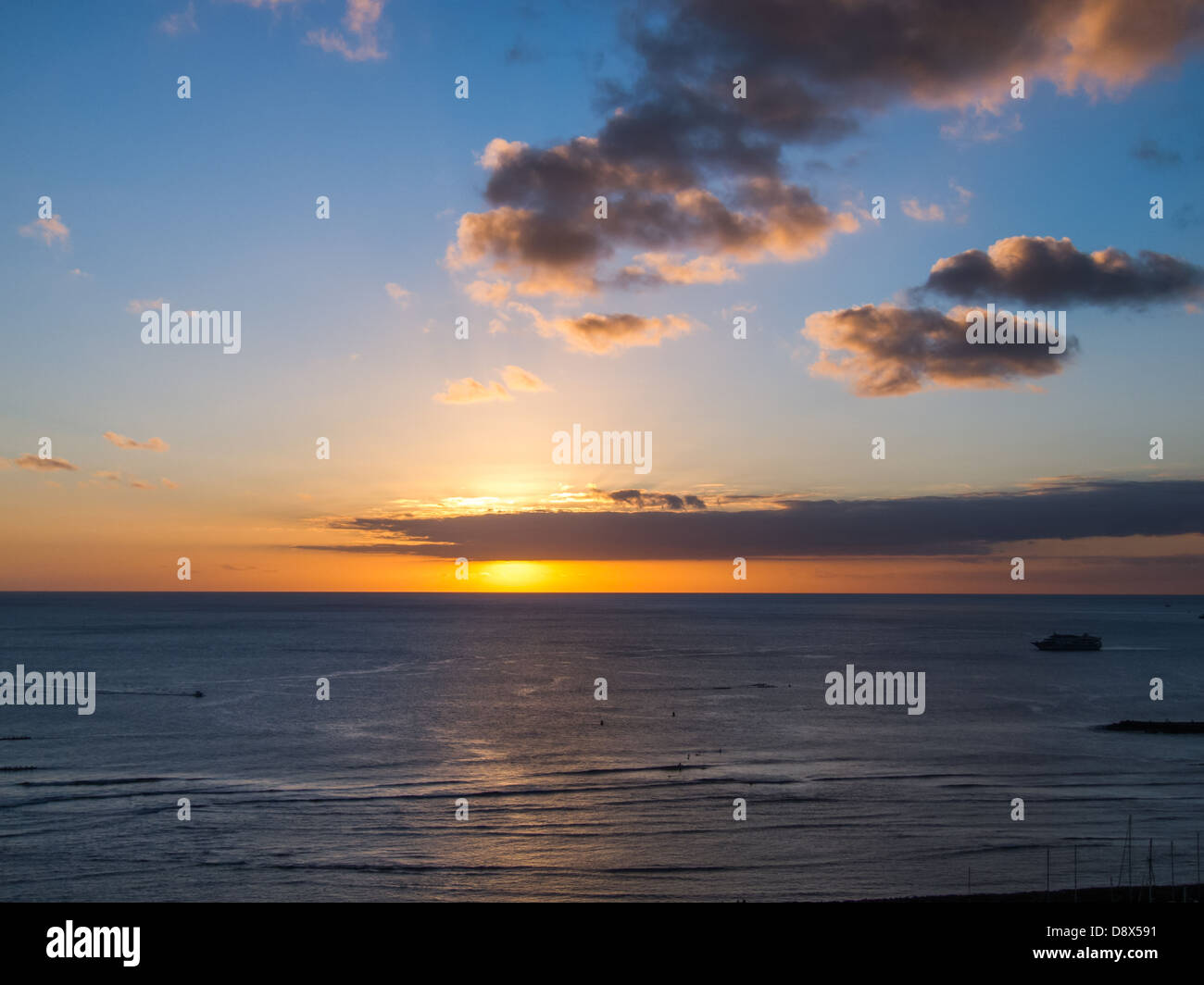 Sunset off of Waikiki with golden highlights reflected in the water Stock Photo