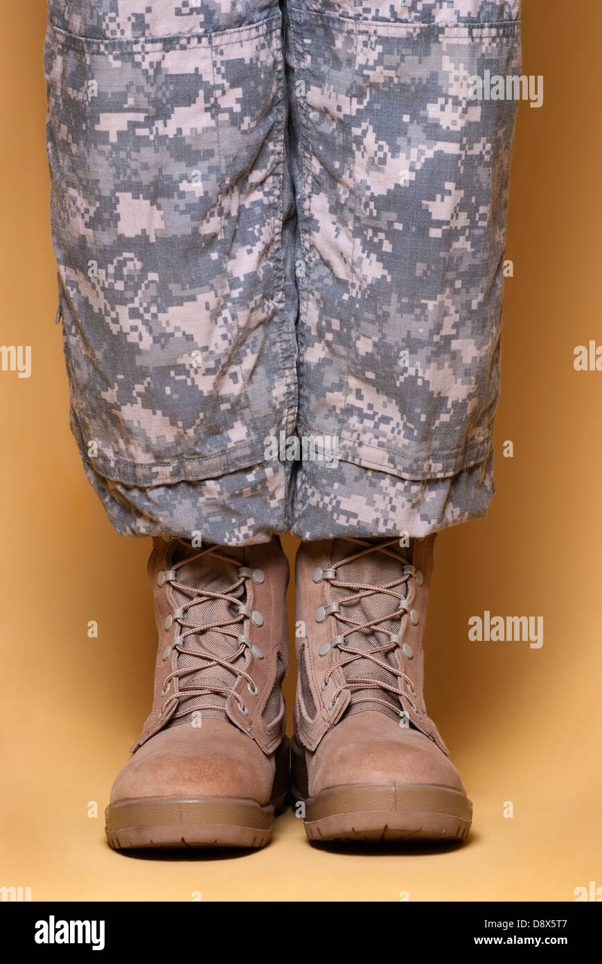 Army combat camouflage uniform pants (ACU) and tan desert combat boots. Stock Photo