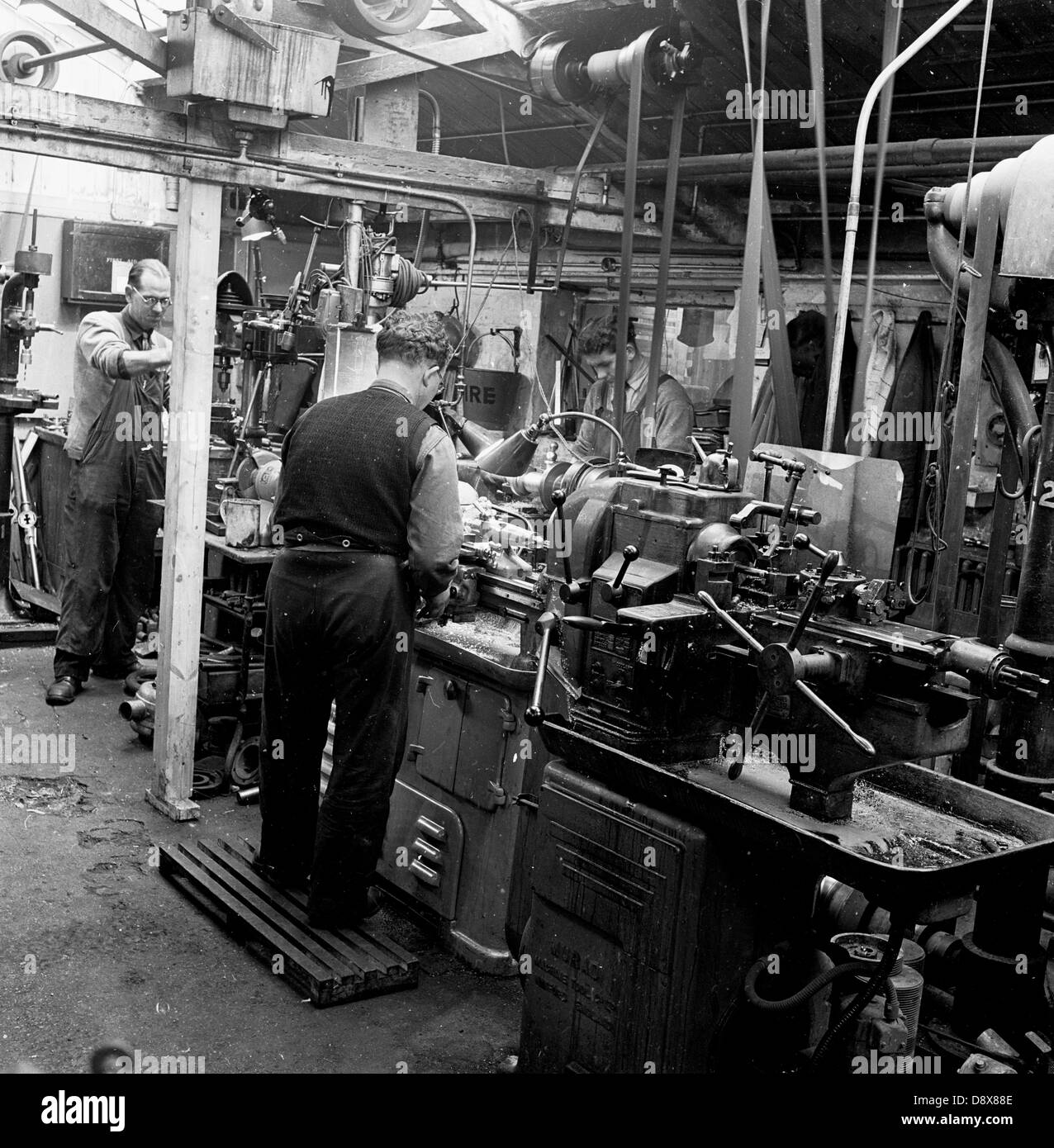 Historical picture from 1950s of male workers using machines on the