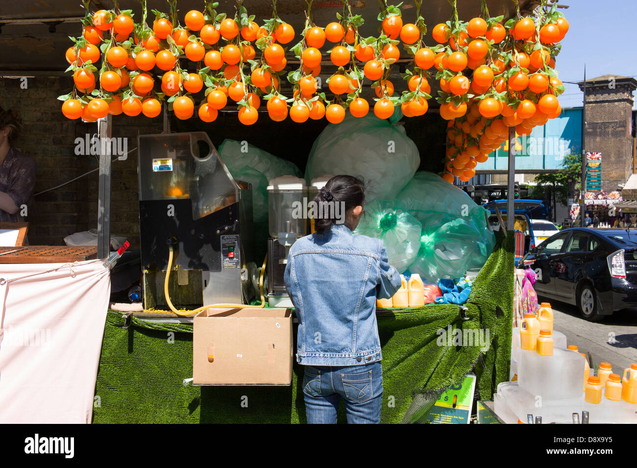 London UK, Camden Town, Camden Market, woman making orange juice a market stall Stock Photo