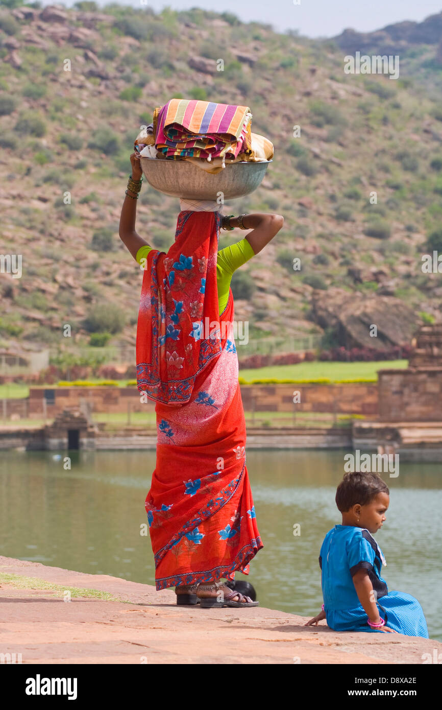 Asia, India, Karnataka, Badami, Agastya lake, Indian woman carries washed clothes on her head Stock Photo