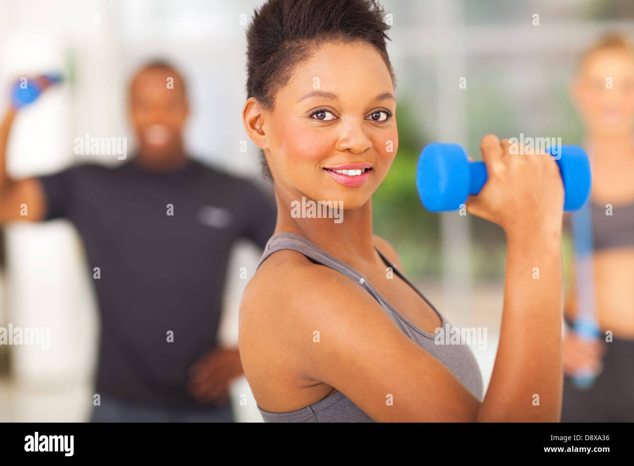 beautiful fit african woman lifting dumbbell Stock Photo