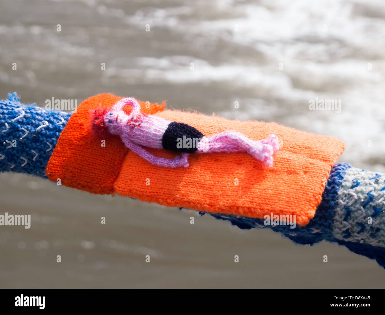 Yarn Bombing decorating public places with knitted objects here a sunbather on the Saltburn pier handrail Stock Photo