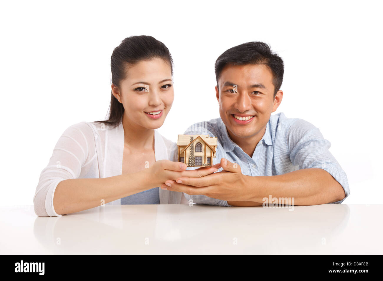 Young couple holding house model Stock Photo - Alamy