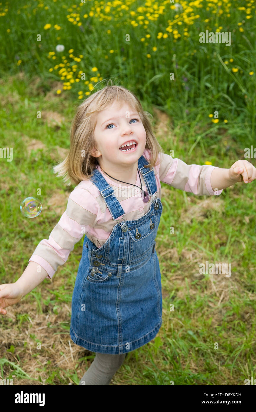 Four year-old girl playing with soap bubbles Stock Photo