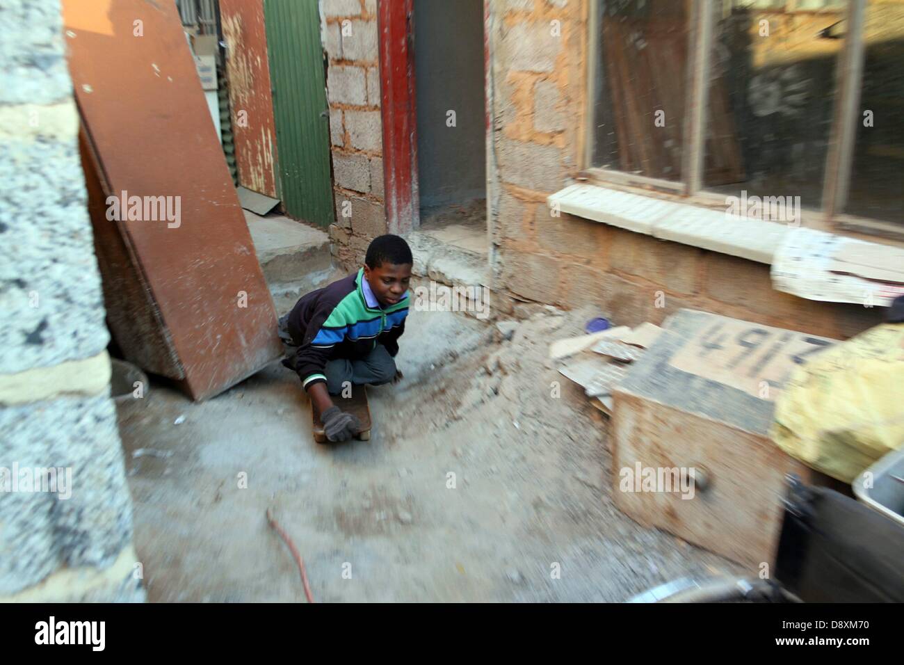 JOHANNESBURG, SOUTH AFRICA: Thabang Diholo on June 5, 2013, in Johannesburg, South Africa. Born paraplegic, Diholo is wheelchair bound but prefers to move around using an old skateboard. The 16-year-old does not require any special treatment from his peers and is determined to study further, towards a better life. (Photo by Gallo Images / Sowetan / Bafana Mahlangu) Stock Photo