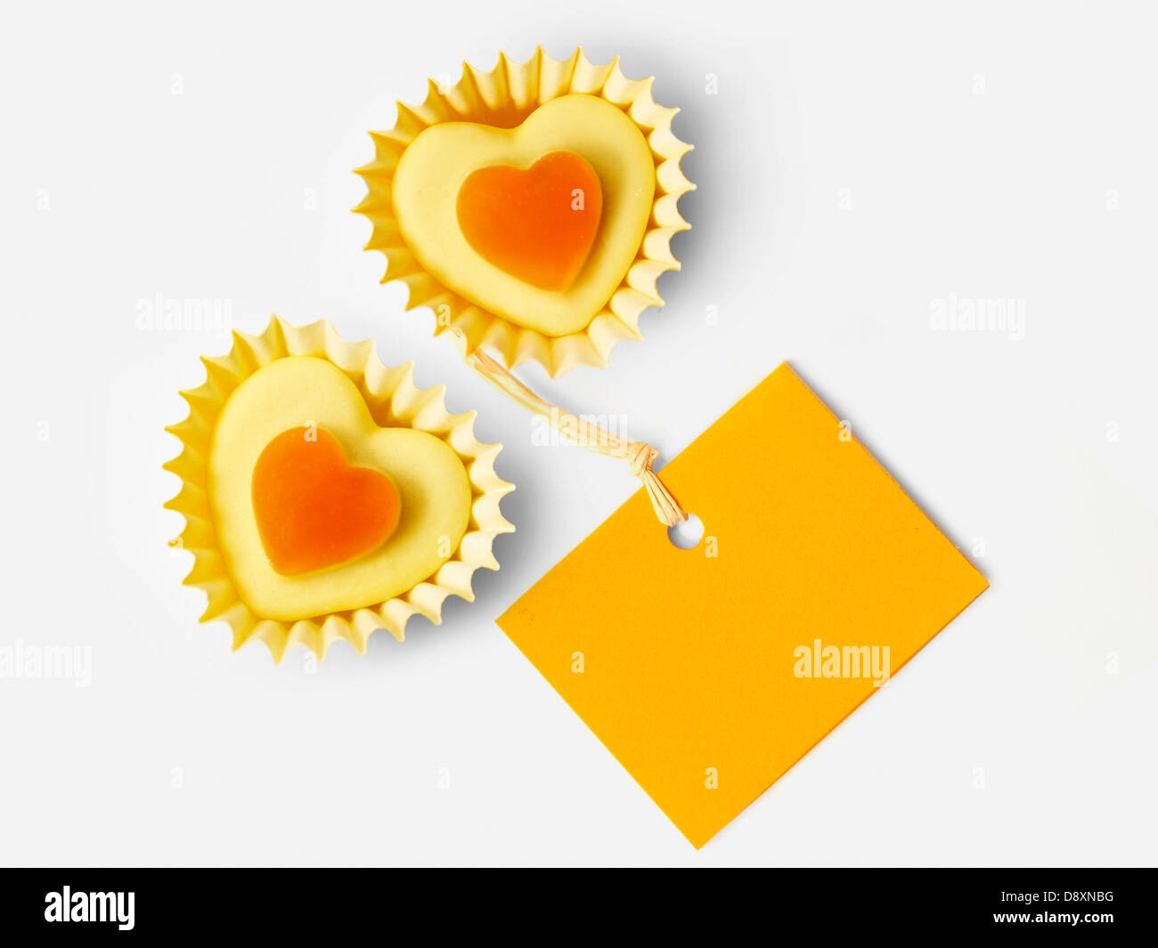 Small orange candies in heart-shaped paper cups and a label Stock Photo ...