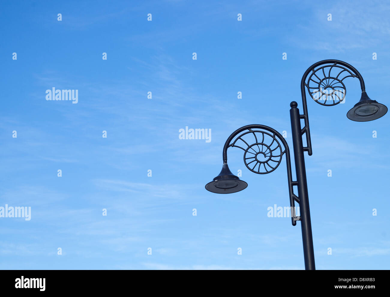 A set of Victorian lights on a lamp post against a clear, blue sky. Stock Photo