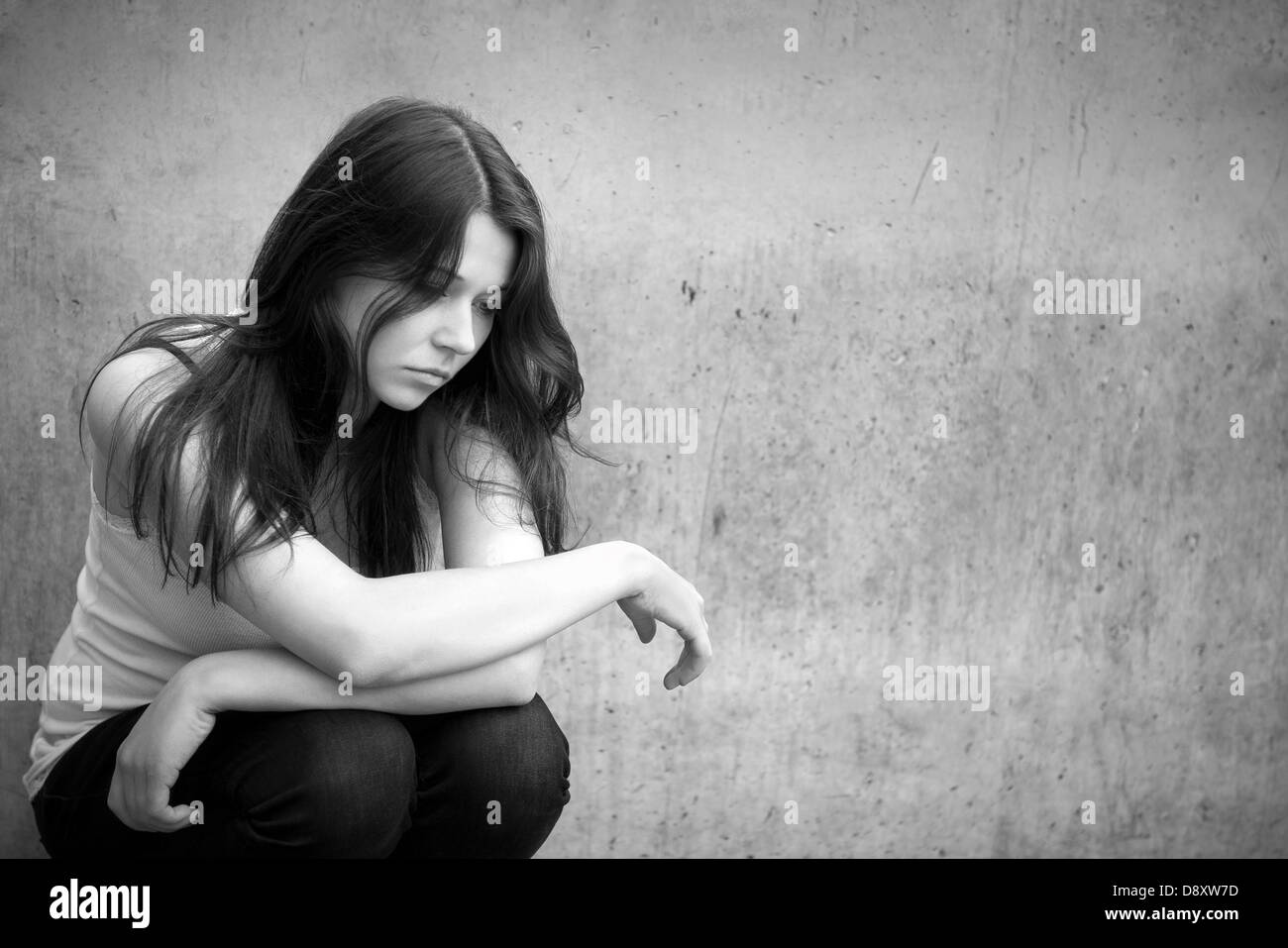 Outdoor portrait of a sad teenage girl looking thoughtful about troubles, monochrome photo Stock Photo