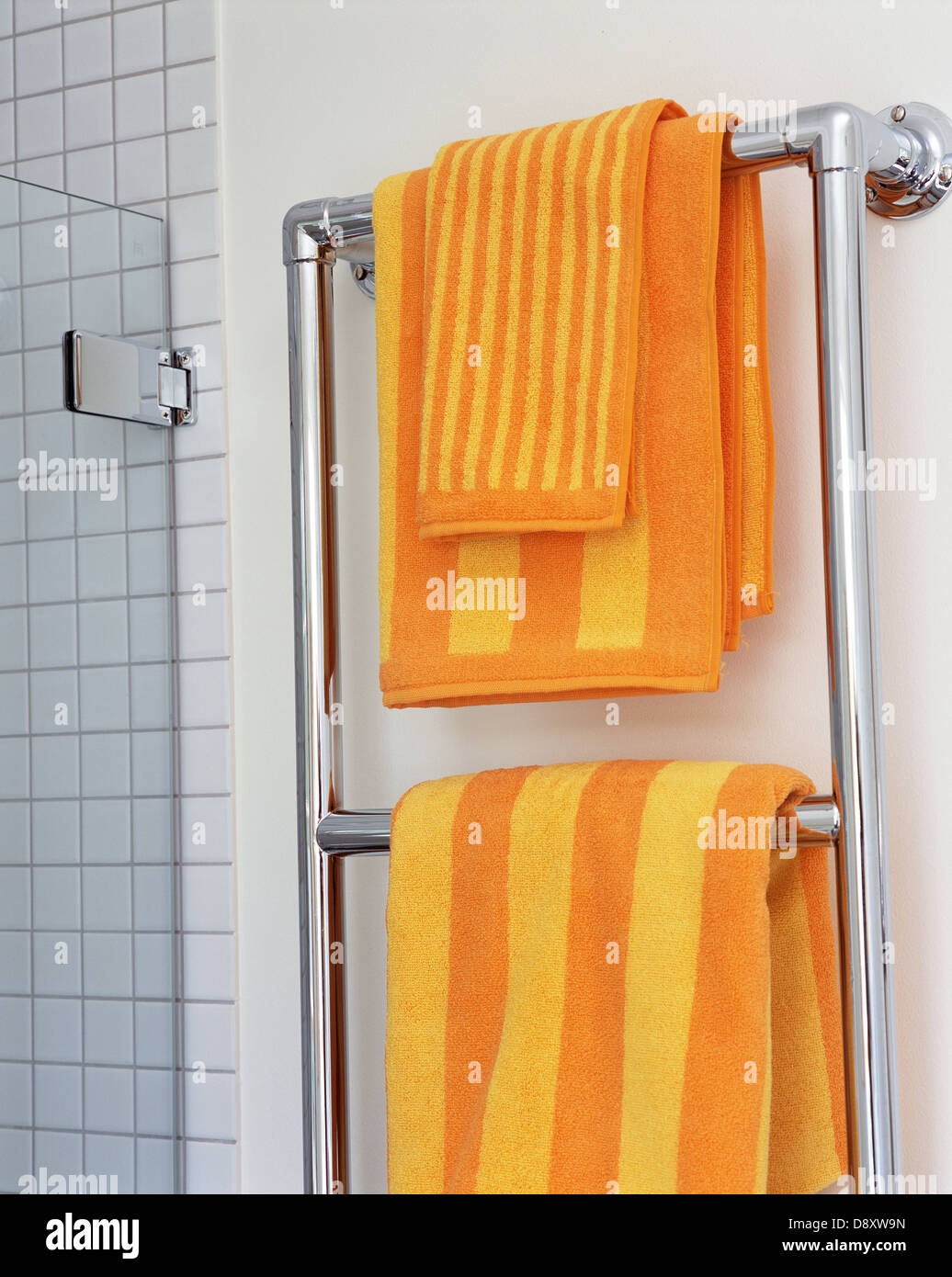 Towels on rail by wall in bathroom Stock Photo - Alamy