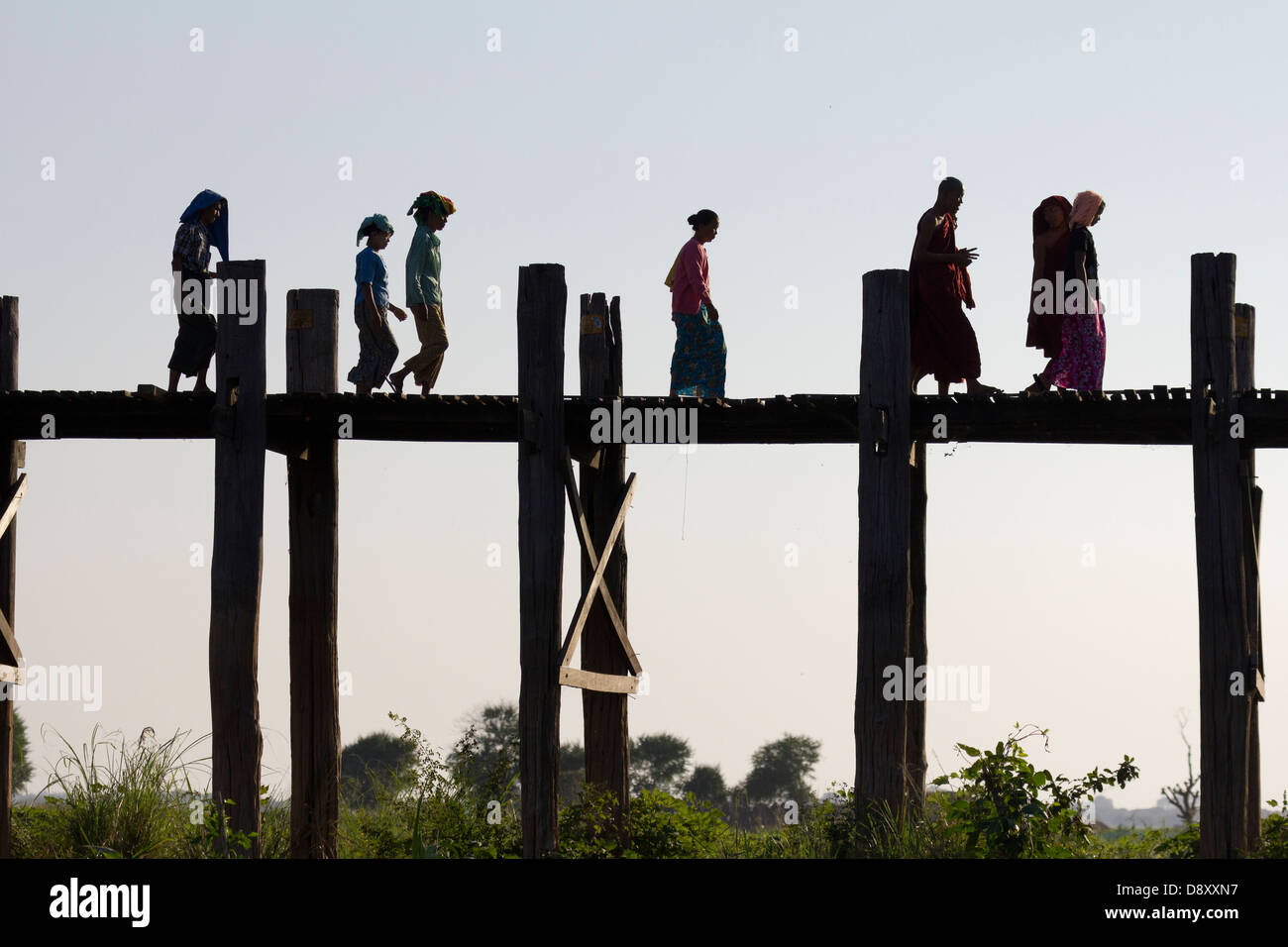 Women and monks Crossing U Bein Teak Bridge across Taungthaman Lake ...