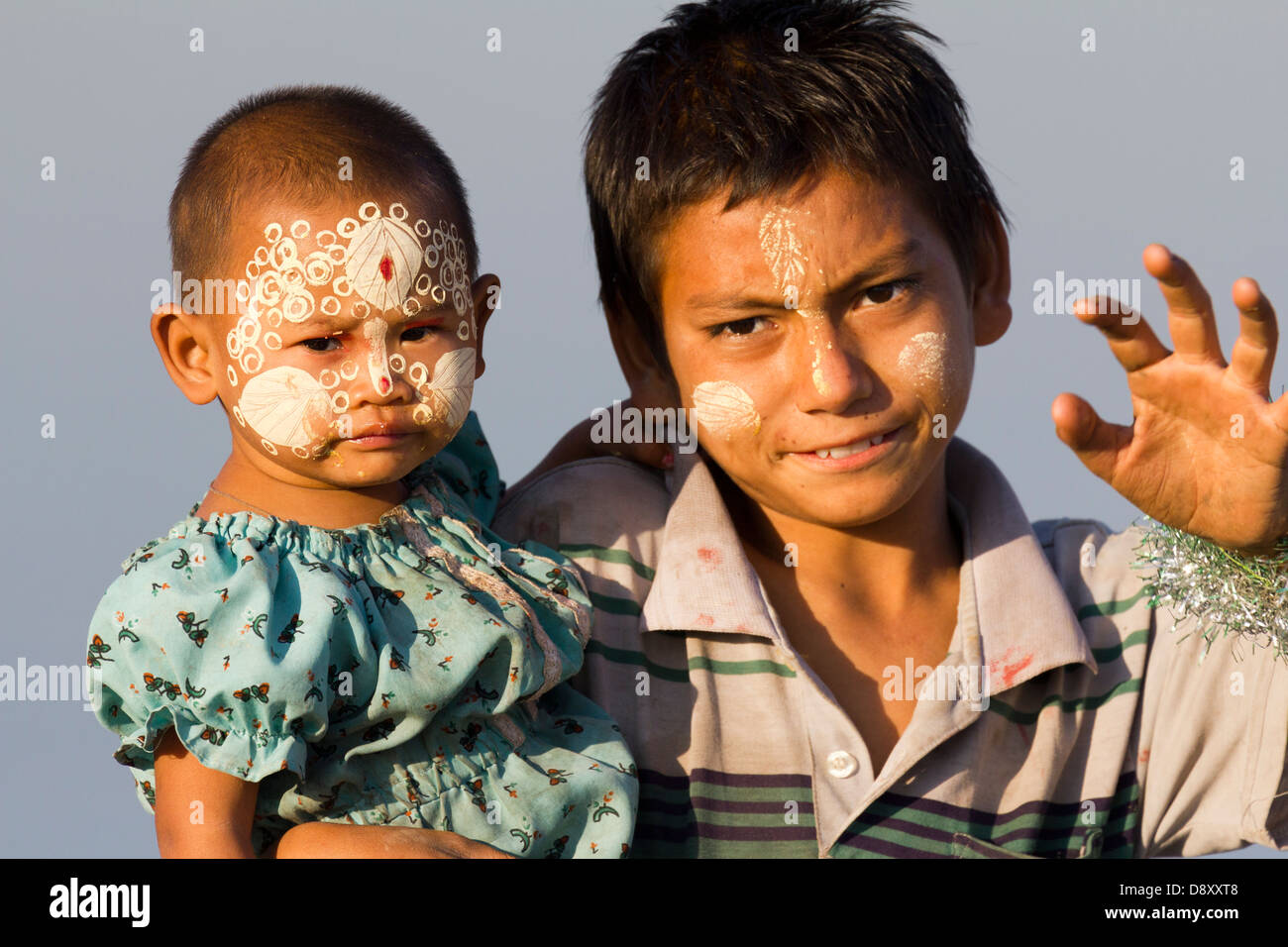 A young girl and boy with elaborate Thanaka face decoration by U Bein Teak Bridge Myanmar 2 Stock Photo
