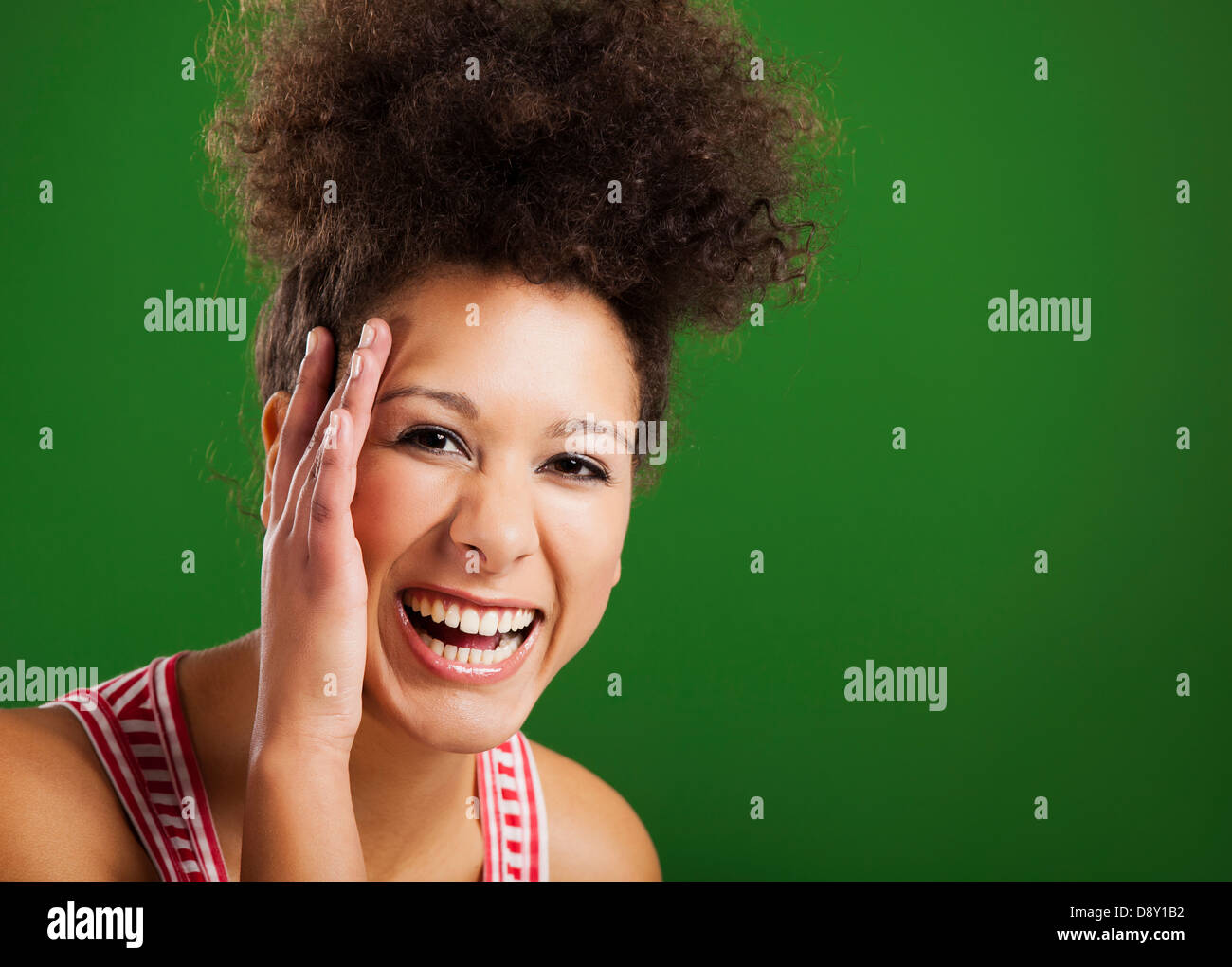 Beautiful African woman laughing over a green background Stock Photo ...