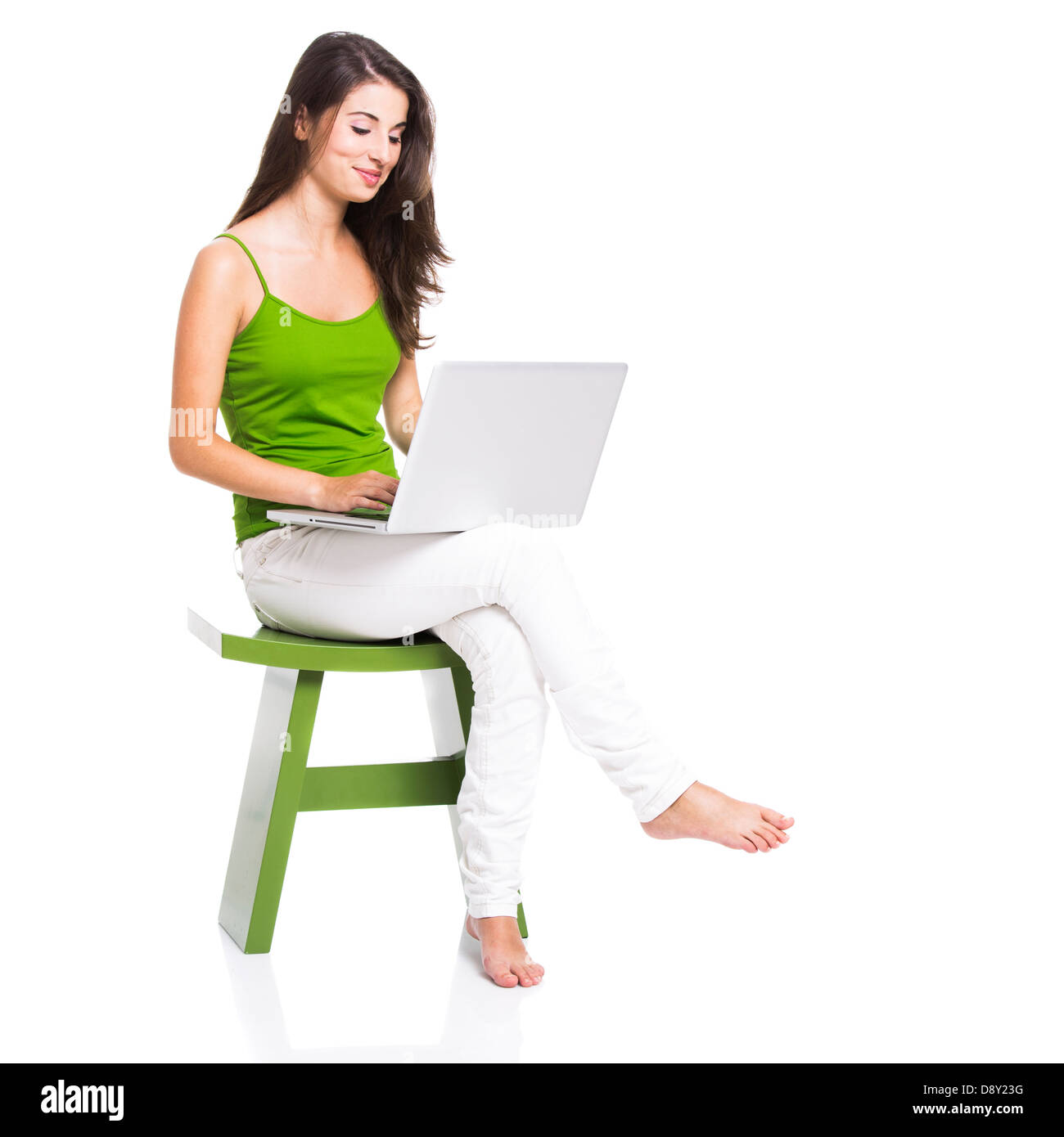 Beautiful woman sitting in a chair working with a laptop, isolated over a white Stock Photo