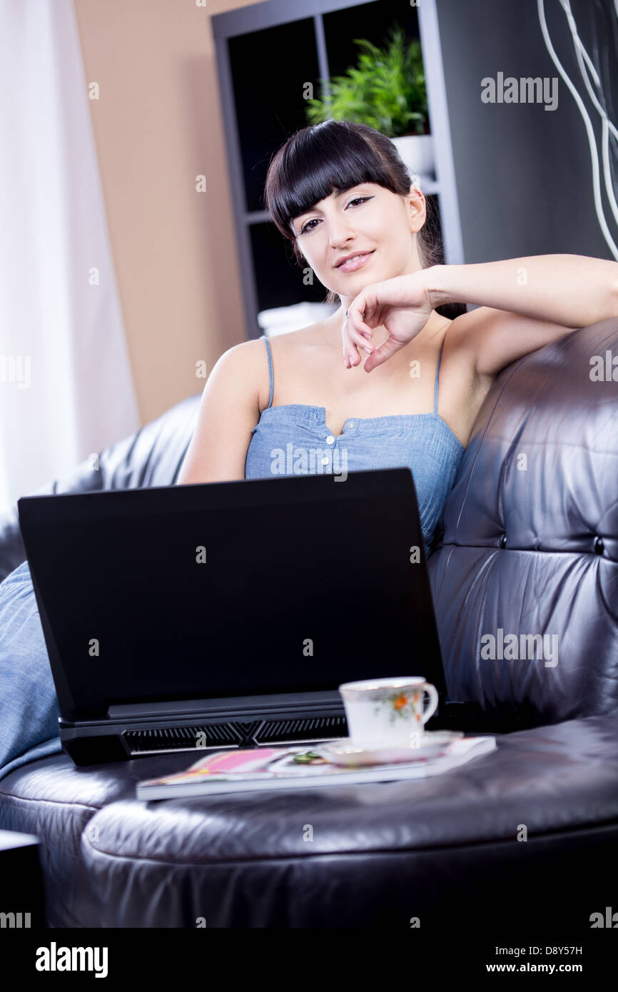 portrait of a young woman with a laptop in the living room Stock Photo