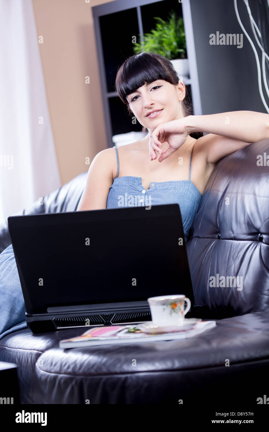portrait of a young woman with a laptop in the living room Stock Photo ...