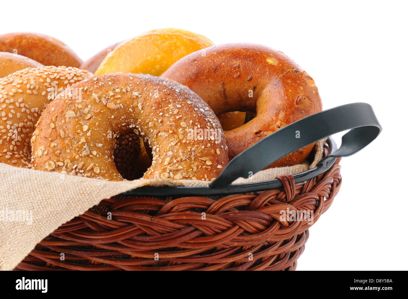Closeup of assorted fresh bagels in a basket, including egg, sesame seed, multi-grain, plain, and cinnamon raisin. Stock Photo