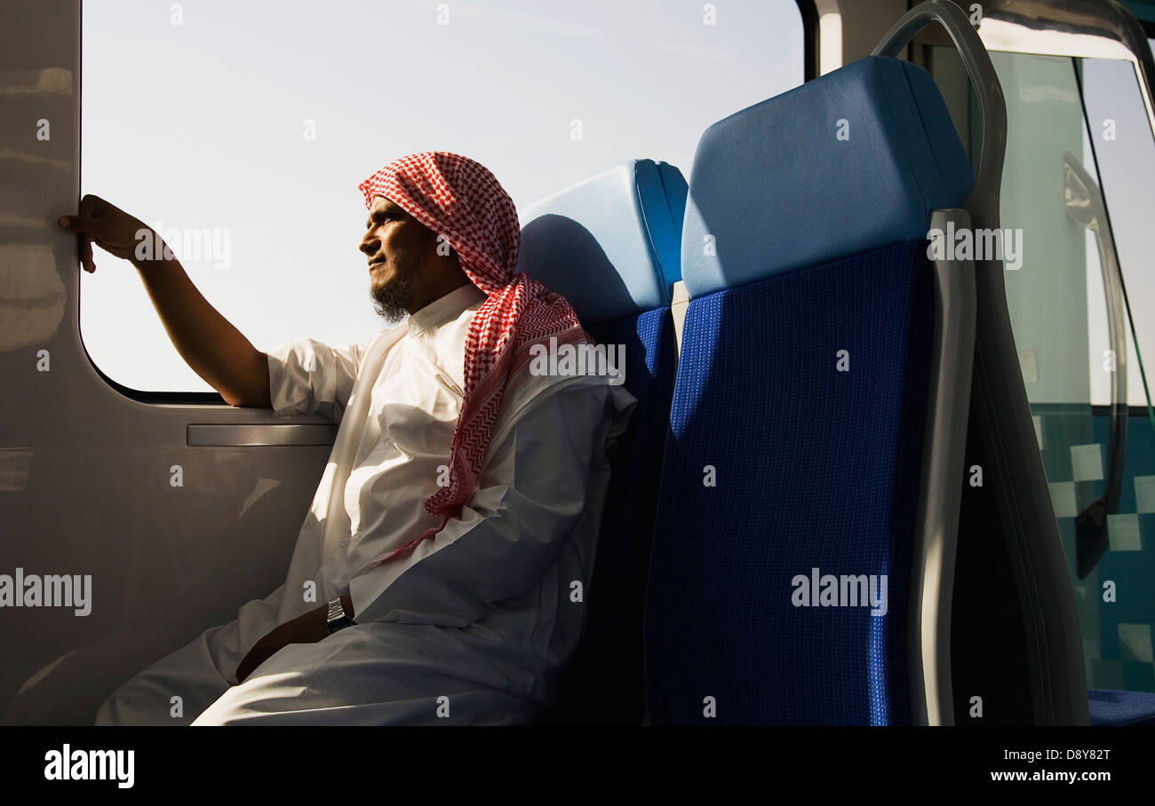 UAE, Dubai, Arab male in Dishdasha on Dubai Metro train. Stock Photo