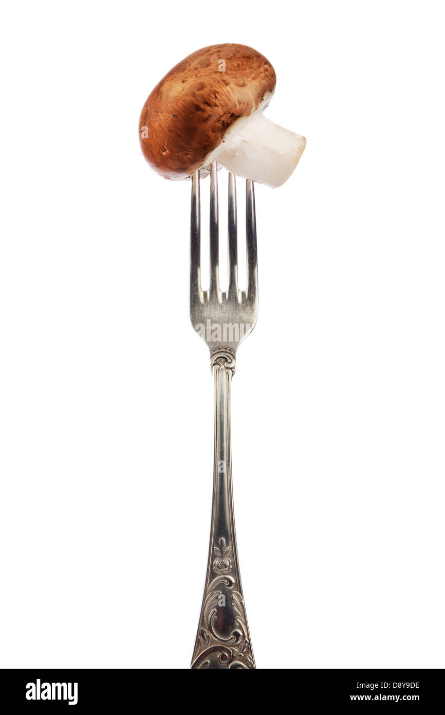 brown mushroom sticked on silver fork Stock Photo
