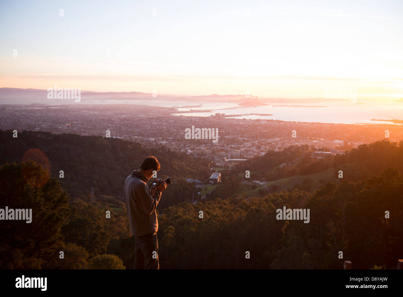 young man filming sunset Stock Photo
