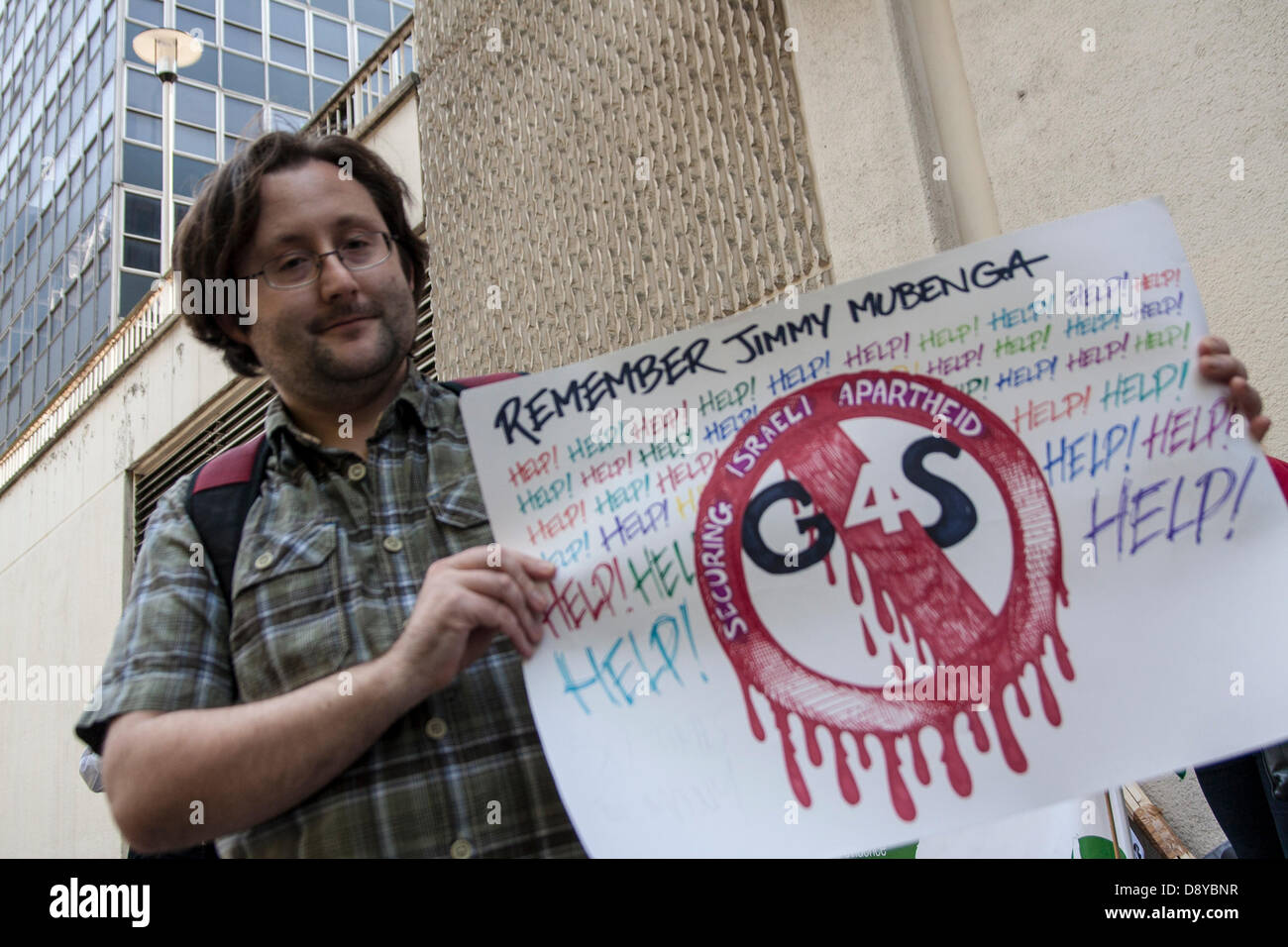 A protester outside the AGM of security multinational G4S demonstrates against the company who he accuses of being complicit in the death of UK deportee Jimmy Mubenga who dies as he was being placed aboard a plane back to Angola. Credit:  Paul Davey/Alamy Live News Stock Photo
