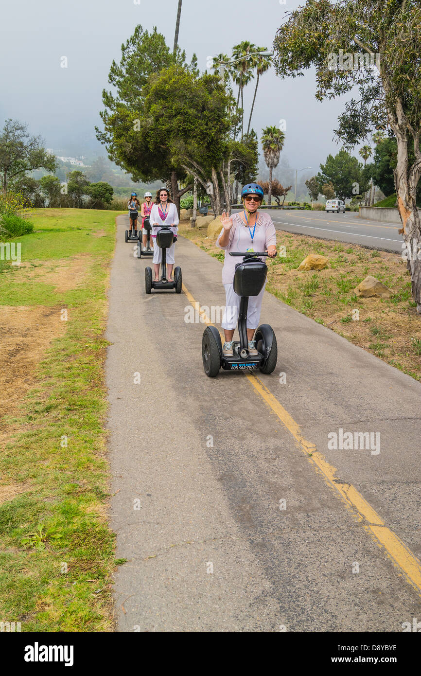 A group of Segway personal transporter riders wearing helmets drive their Segways on a bicycle path in Santa Barbara, California Stock Photo