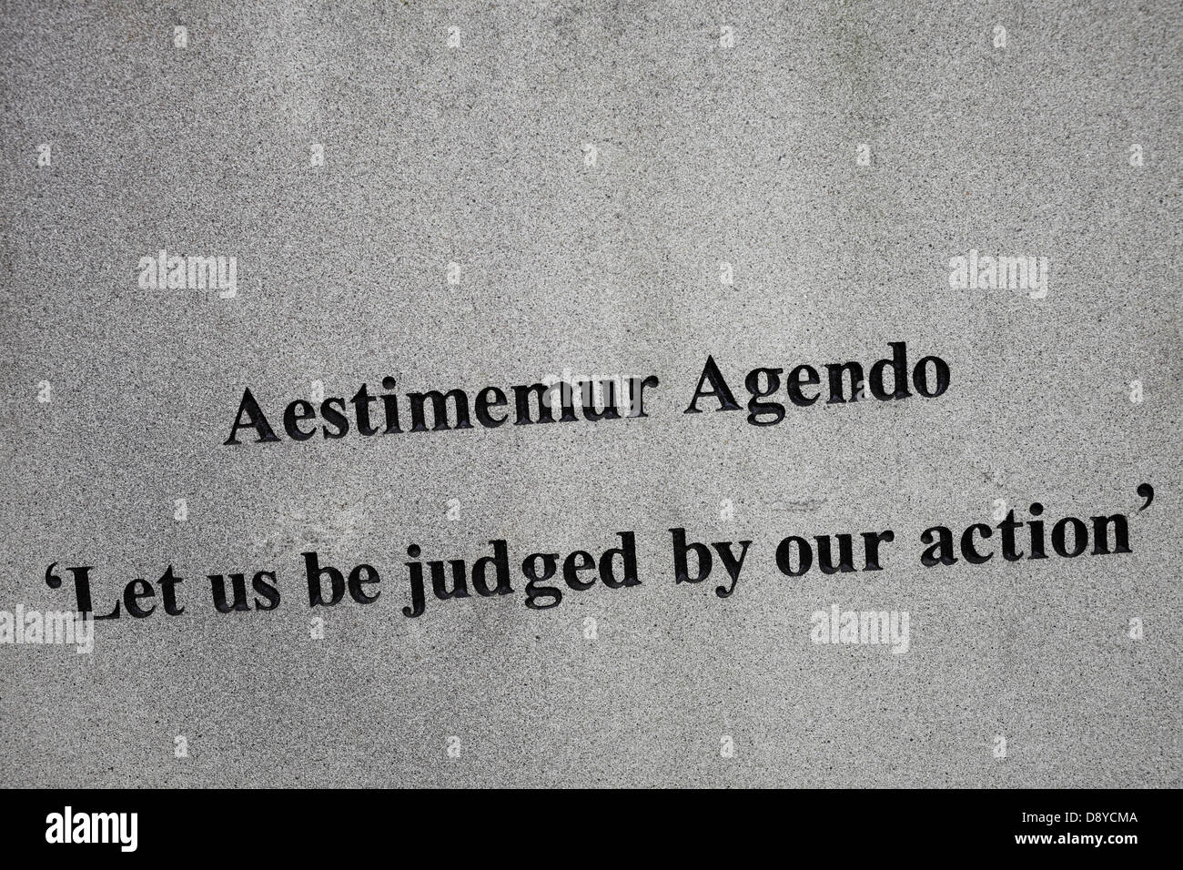 Motto 'Let us be judged by our action' on a headstone. Stock Photo