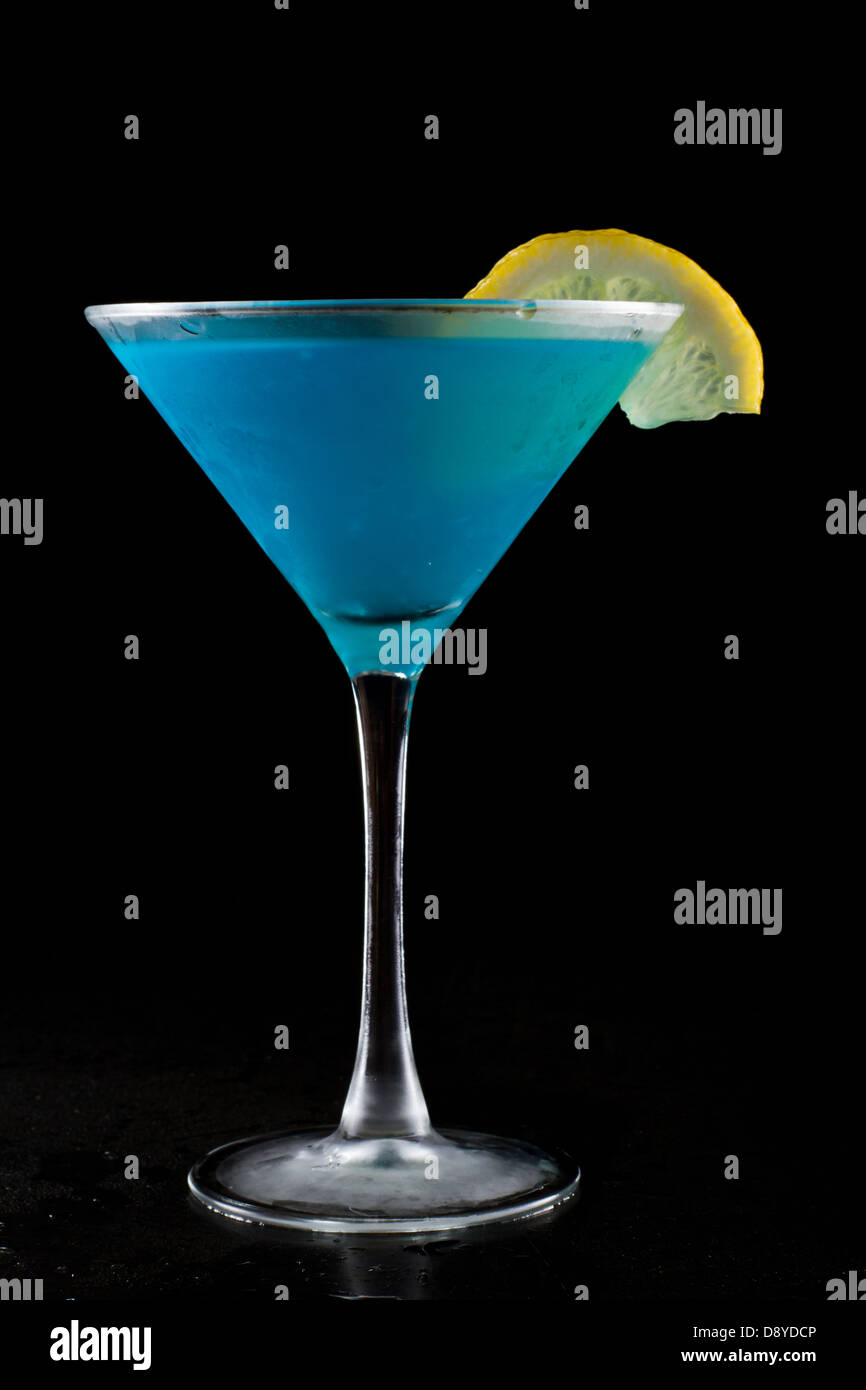 bright blue lemonade served in a martini isolated on a black background