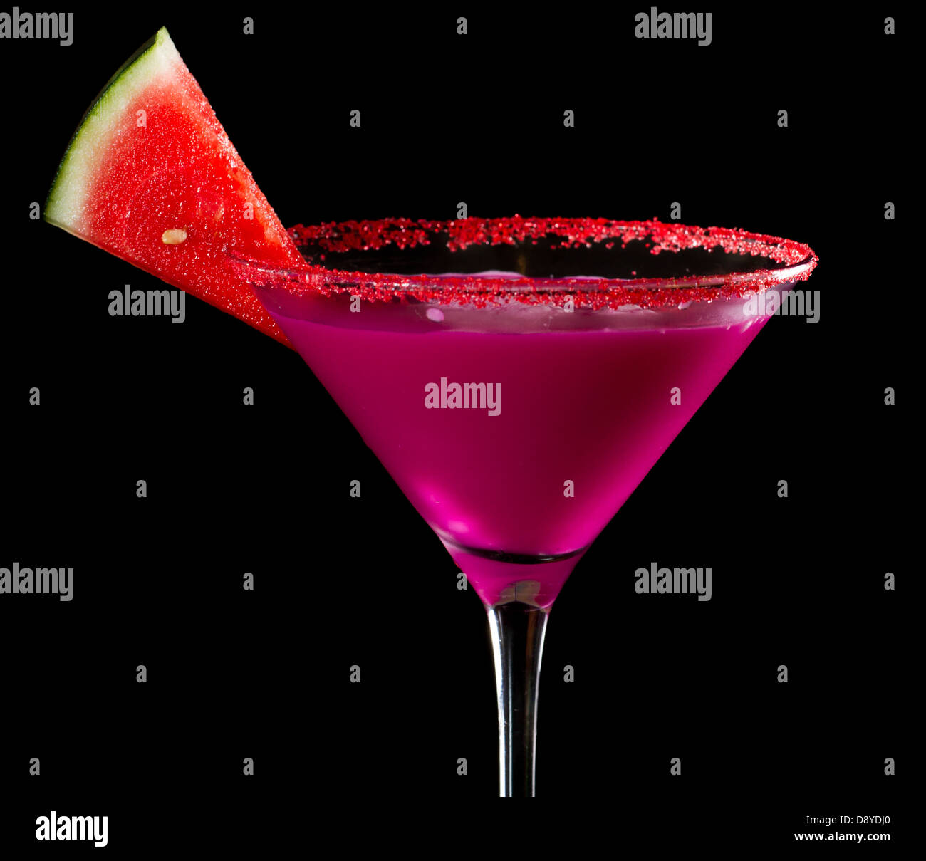 bright colorful watermelon martini isolated on a black background garnished with red sugar rim and a watermelon slice Stock Photo