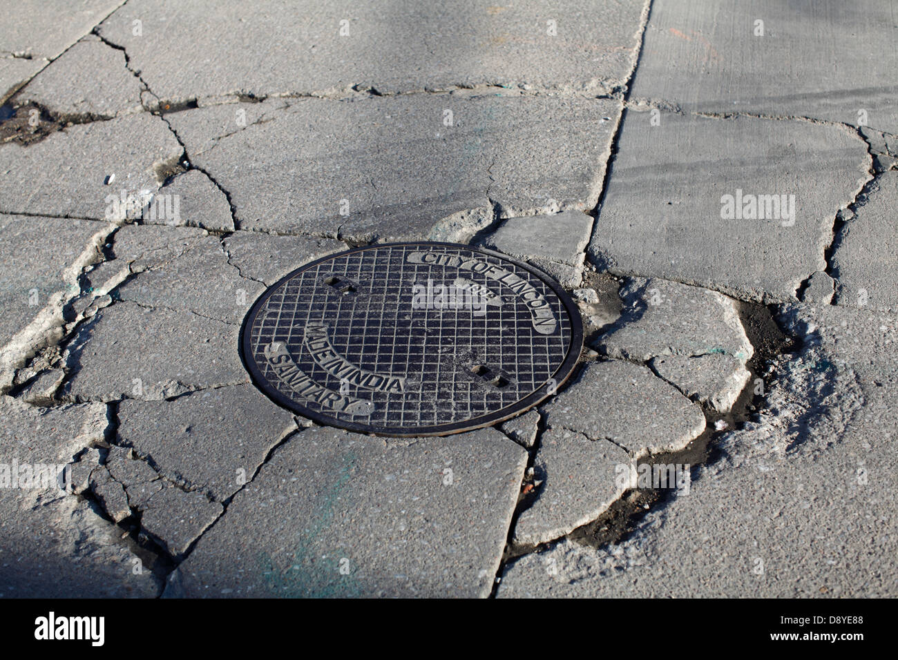 Cracked concrete around manhole cover Stock Photo Alamy