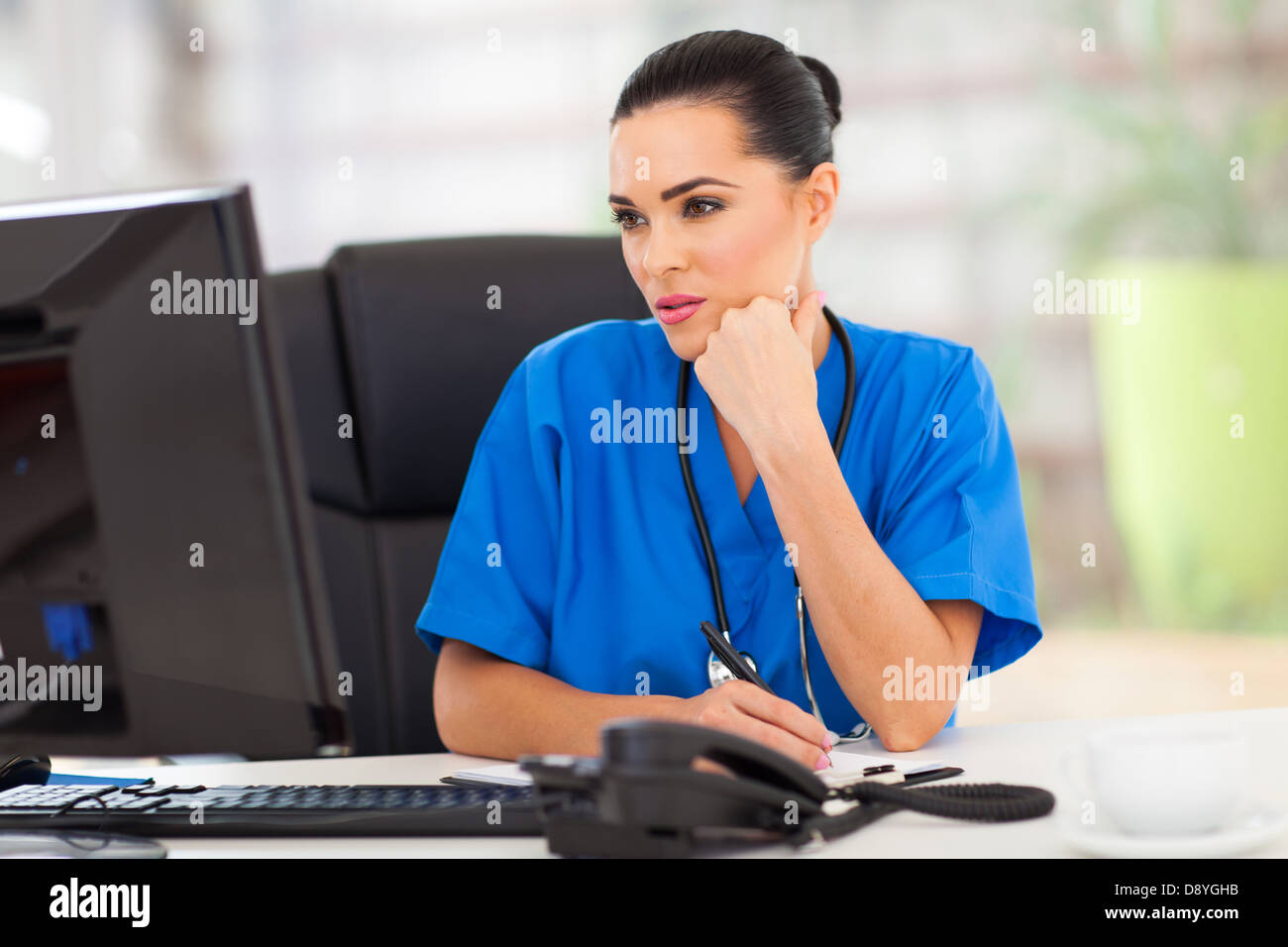 thoughtful medical doctor looking at computer screen in office Stock Photo
