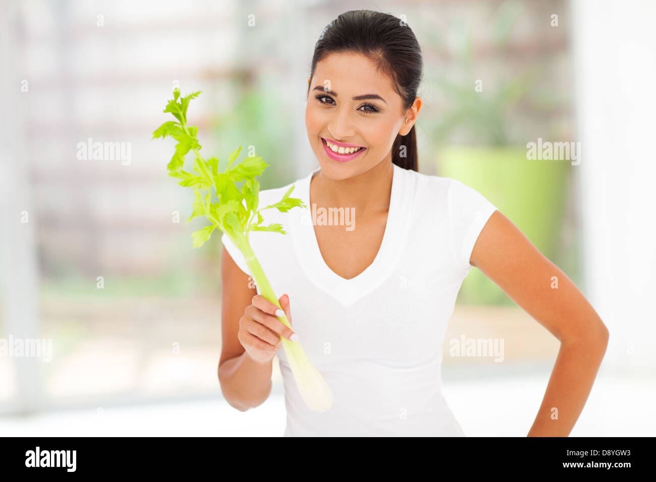 healthy young woman holding celery stick and smiling Stock Photo
