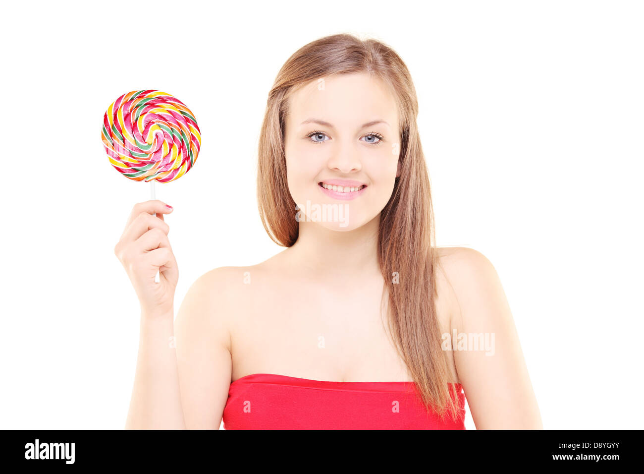 Pretty young girl holding a lollipop and looking at camera isolated on white background Stock Photo