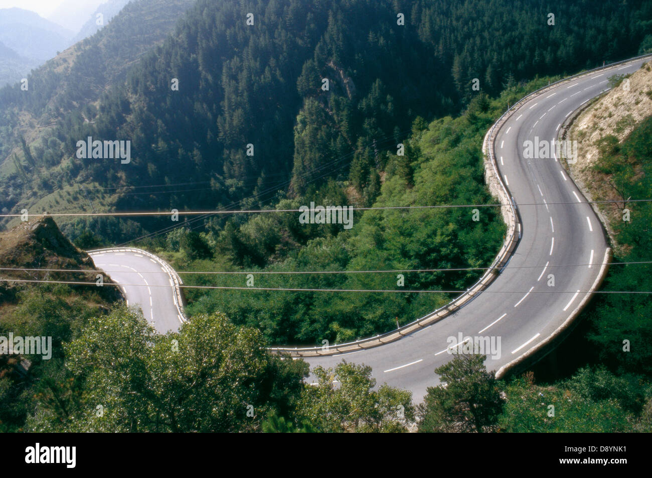 View of curved road running through forest Stock Photo