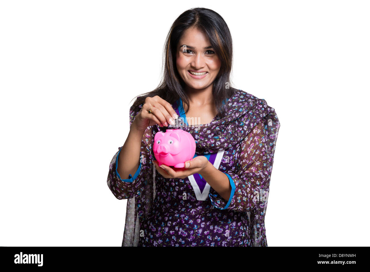 Portrait of a woman inserting coin into a piggy bank and smiling Stock ...