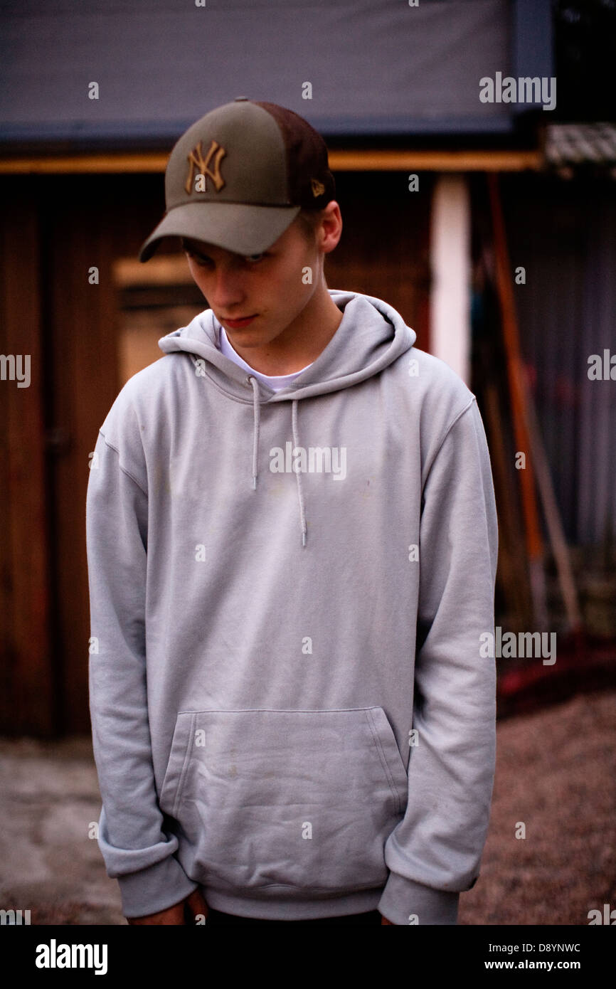 Teenage boy wearing baseball cap with hands in pockets Stock Photo